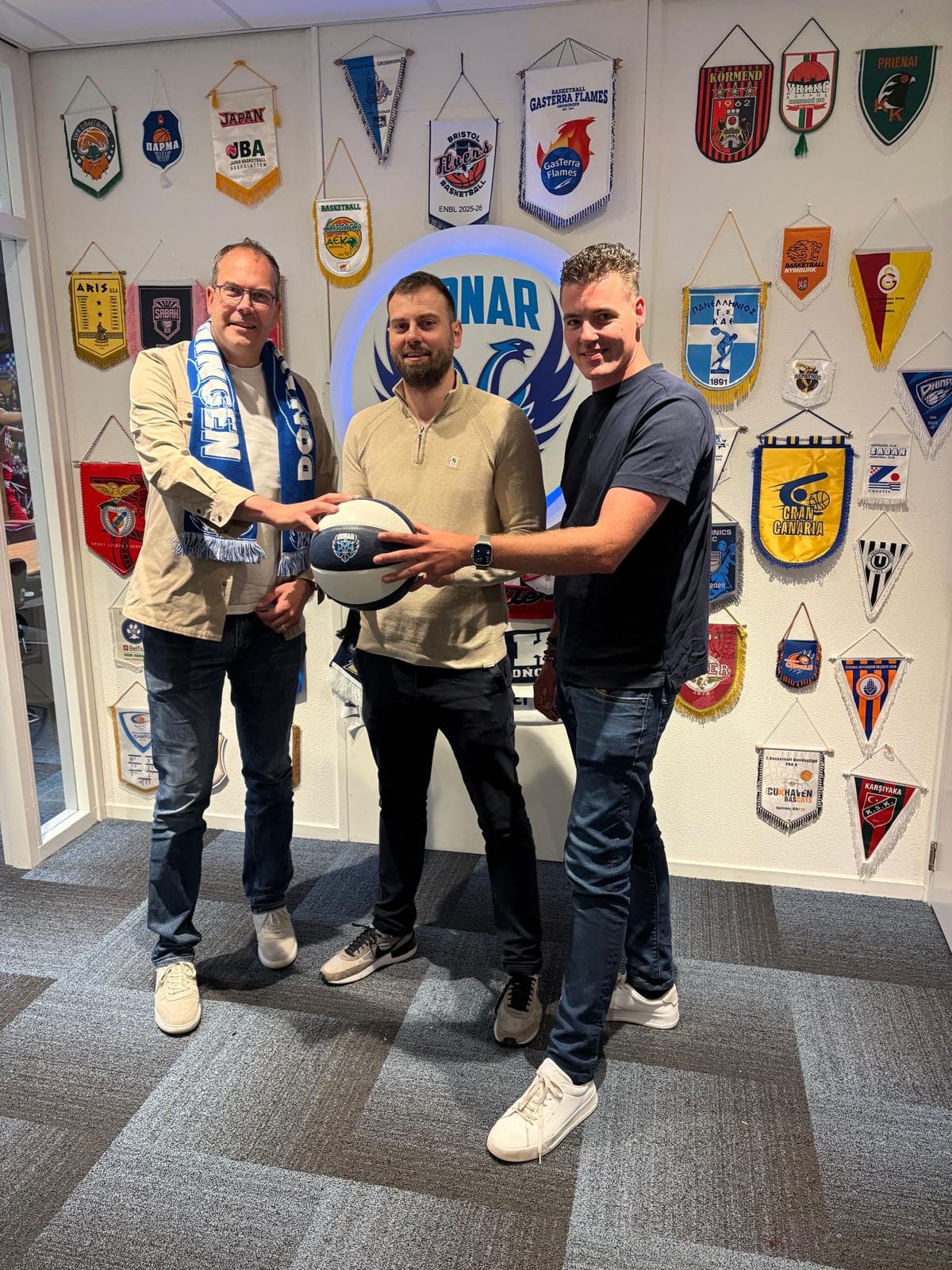 Ivo Rupert, Stefan Mladenovic en Erik Davids met een basketbal in de businessclub van Donar Groningen